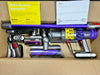 Dyson vacuum cleaner with attachments and warranty card in a box